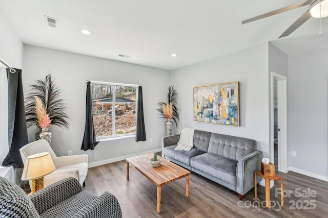 living room with recessed lighting, visible vents, baseboards, and wood finished floors