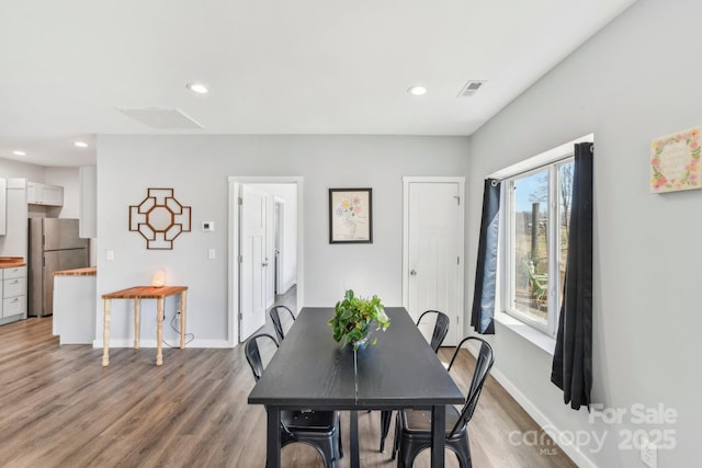 dining area featuring light wood finished floors, visible vents, and recessed lighting