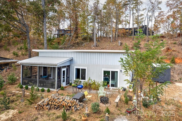 rear view of house with metal roof and a sunroom