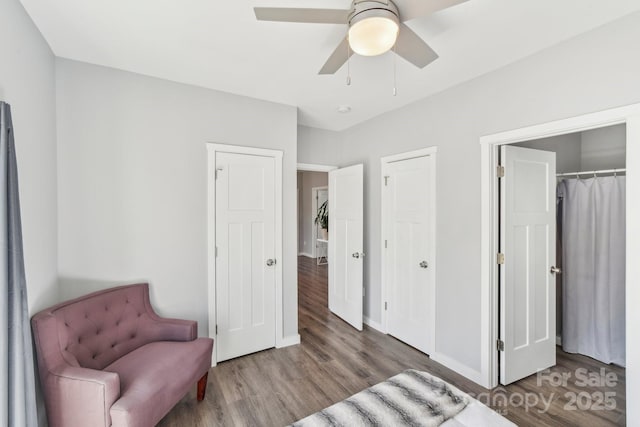 bedroom with a ceiling fan, baseboards, and wood finished floors