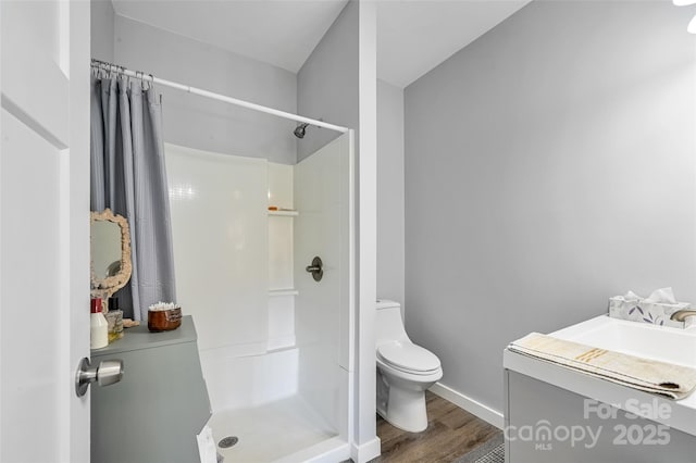 bathroom with wood finished floors, walk in shower, toilet, and baseboards