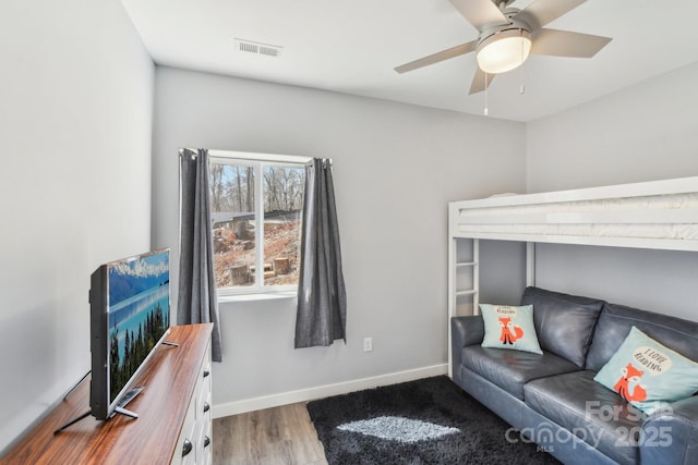 bedroom featuring ceiling fan, wood finished floors, visible vents, and baseboards