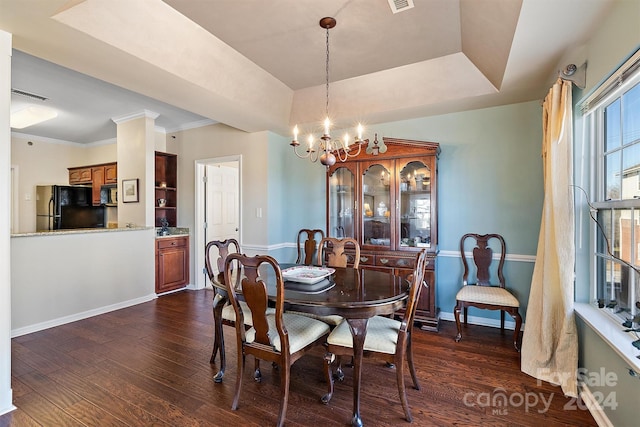 dining room with an inviting chandelier, ornamental molding, and dark hardwood / wood-style flooring