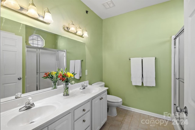 bathroom featuring vanity, tile patterned floors, toilet, and an enclosed shower