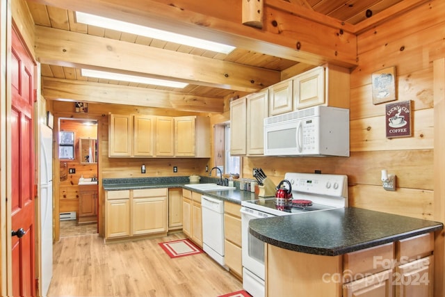 kitchen with wooden walls, sink, beamed ceiling, light wood-type flooring, and white appliances