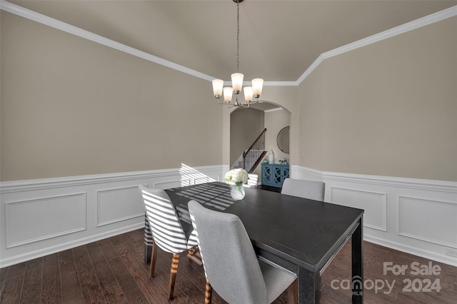 dining area featuring lofted ceiling, ornamental molding, dark wood-type flooring, and an inviting chandelier