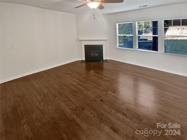 unfurnished living room featuring ceiling fan and dark hardwood / wood-style floors