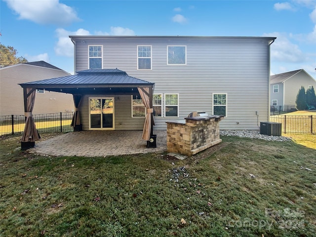 rear view of house featuring a patio, central AC, a gazebo, and a lawn