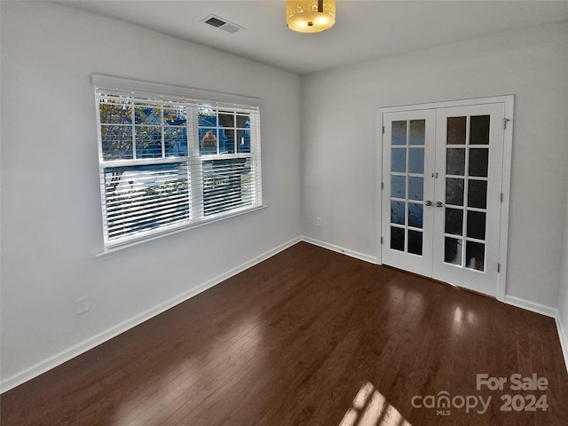 empty room featuring french doors and dark hardwood / wood-style flooring