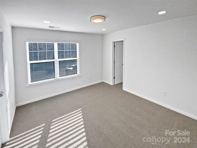 unfurnished room with dark carpet