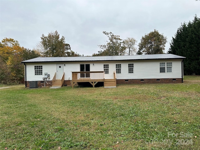 back of house with central air condition unit, a wooden deck, and a lawn