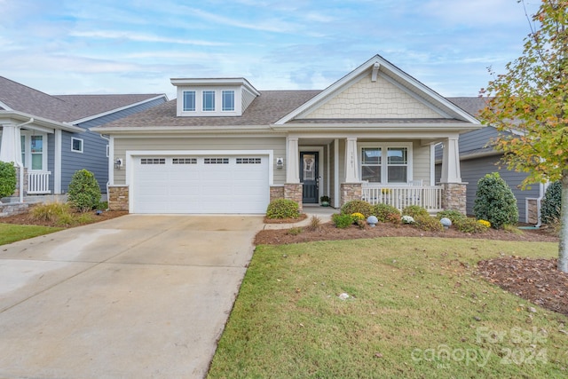 craftsman inspired home with a porch and a front lawn