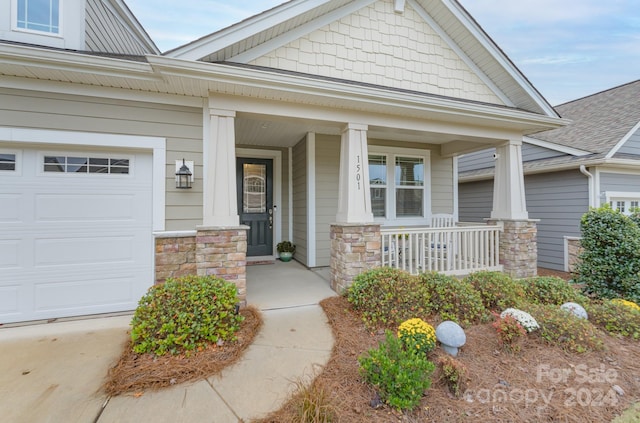 property entrance featuring a garage and a porch