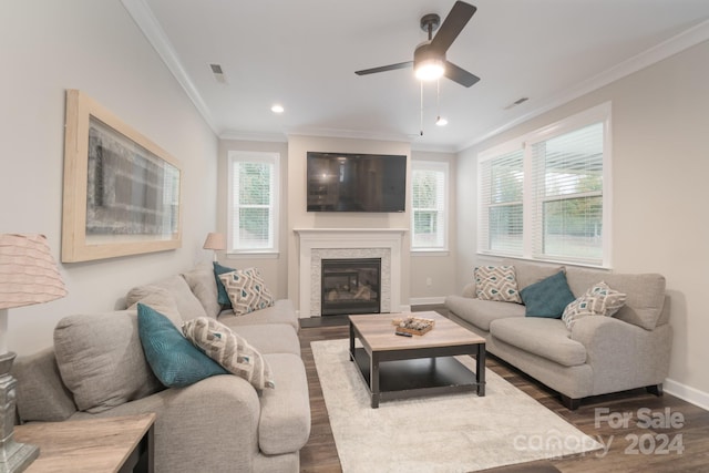 living room with a healthy amount of sunlight, dark hardwood / wood-style flooring, and ornamental molding