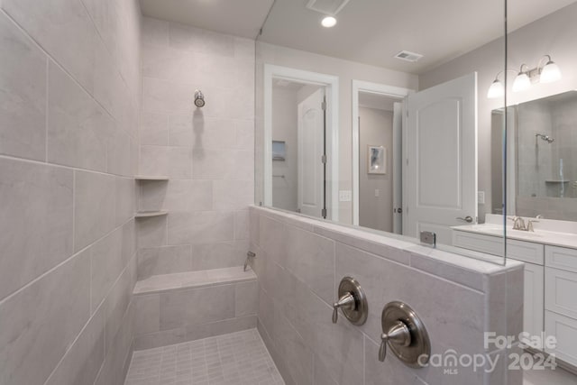 bathroom with vanity and a tile shower