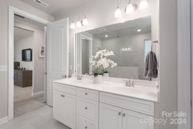 bathroom featuring tiled shower, tile patterned flooring, and vanity