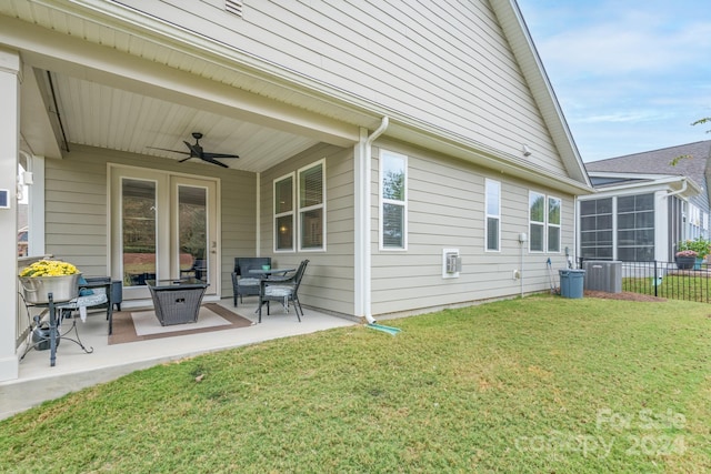 rear view of property with a lawn, ceiling fan, and a patio