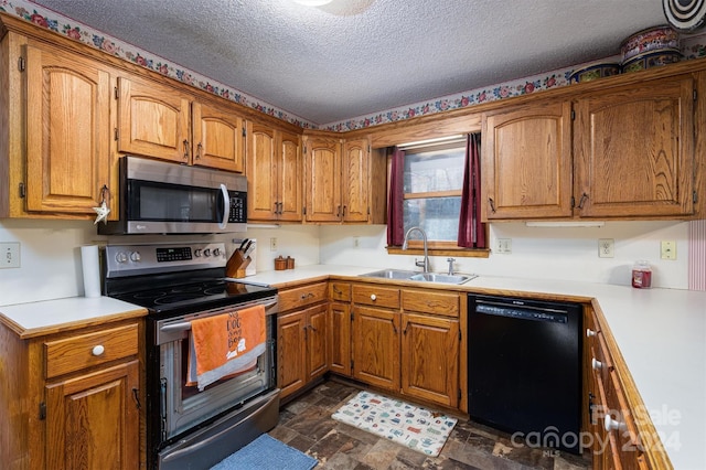 kitchen with black appliances, sink, and a textured ceiling