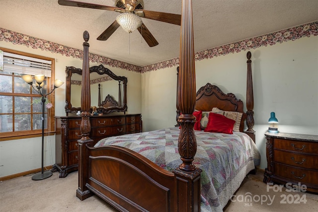 carpeted bedroom featuring ceiling fan and a textured ceiling