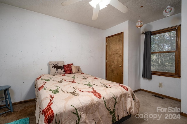 bedroom with a textured ceiling, carpet floors, and ceiling fan