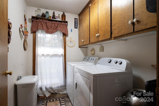 washroom featuring cabinets, a textured ceiling, and separate washer and dryer