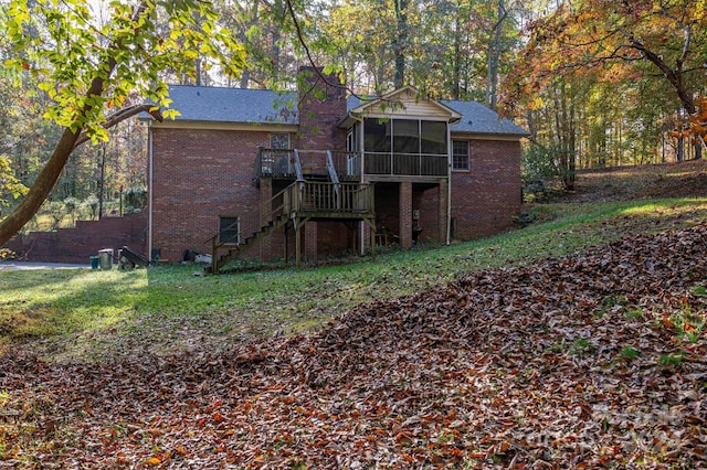 rear view of house with a wooden deck and a sunroom