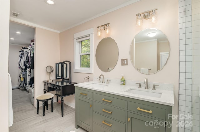 bathroom featuring wood-type flooring, vanity, and ornamental molding