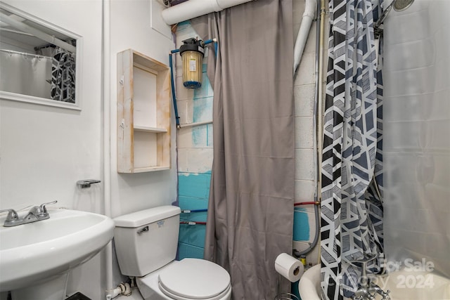 bathroom with a shower with shower curtain, sink, and toilet