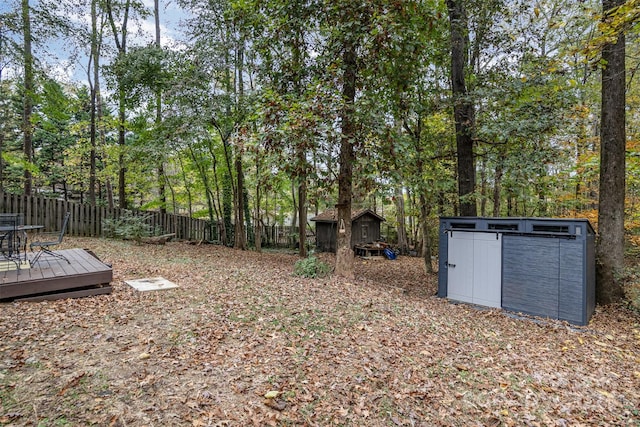 view of yard featuring a storage unit and a wooden deck