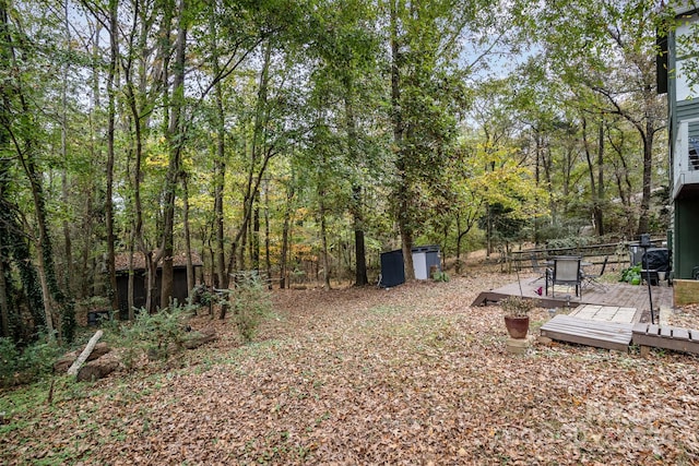 view of yard featuring a shed and a wooden deck