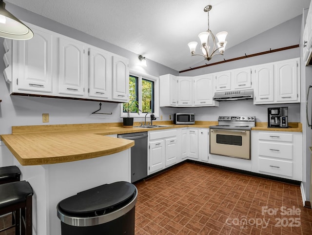 kitchen with pendant lighting, stainless steel appliances, kitchen peninsula, and white cabinets