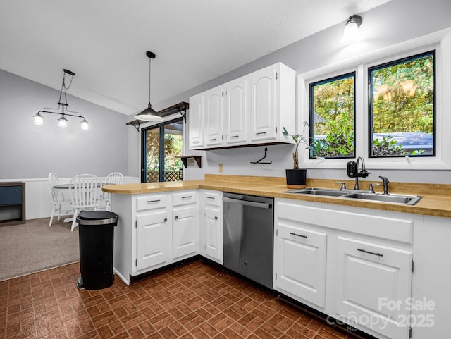 kitchen featuring sink, decorative light fixtures, stainless steel dishwasher, kitchen peninsula, and white cabinets