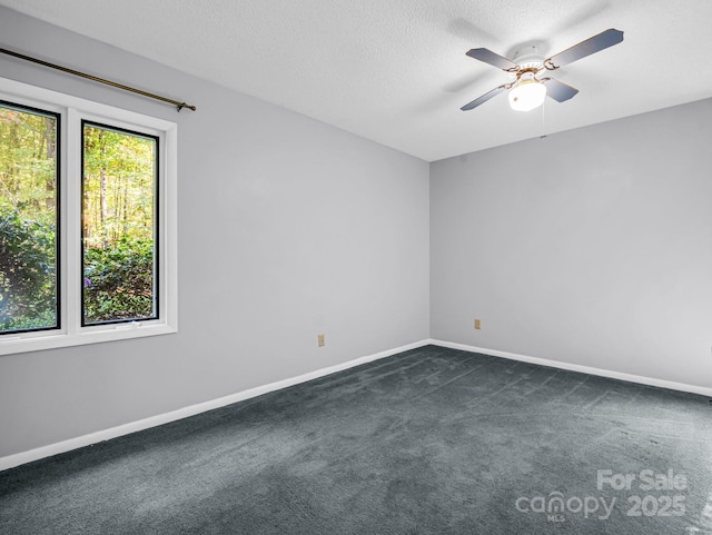 empty room with ceiling fan, a textured ceiling, and dark colored carpet