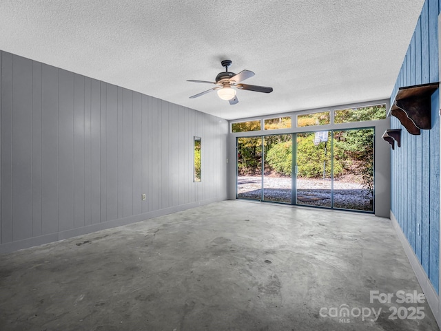 spare room with concrete flooring, ceiling fan, and a textured ceiling