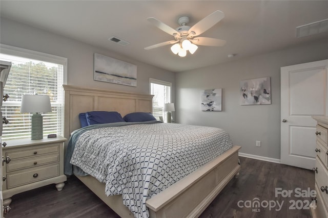 bedroom with ceiling fan, multiple windows, and dark hardwood / wood-style flooring