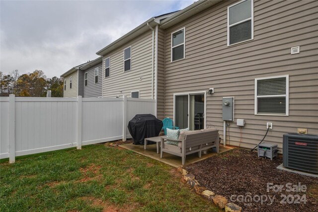 back of property with central AC, a yard, and an outdoor hangout area