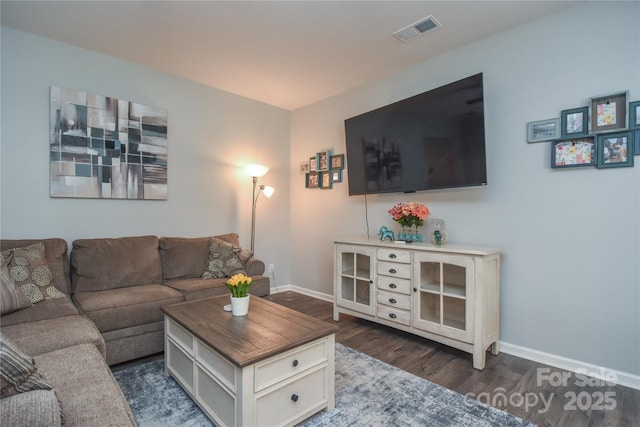 living room with baseboards, dark wood-type flooring, and visible vents