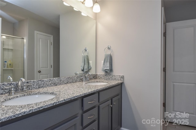full bathroom featuring a sink, double vanity, and a stall shower