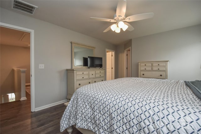 bedroom featuring visible vents, a ceiling fan, dark wood-type flooring, baseboards, and attic access