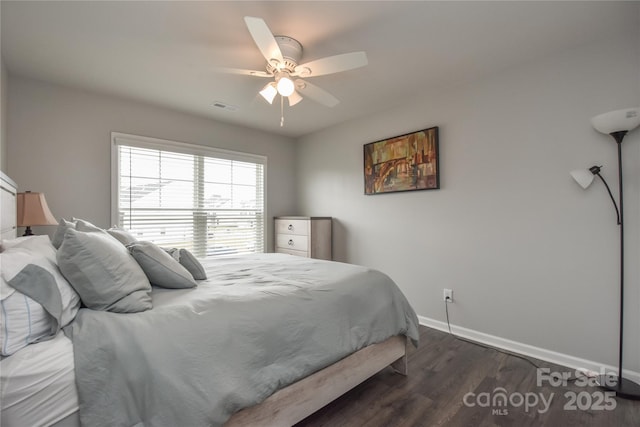 bedroom featuring dark wood-type flooring, visible vents, a ceiling fan, and baseboards