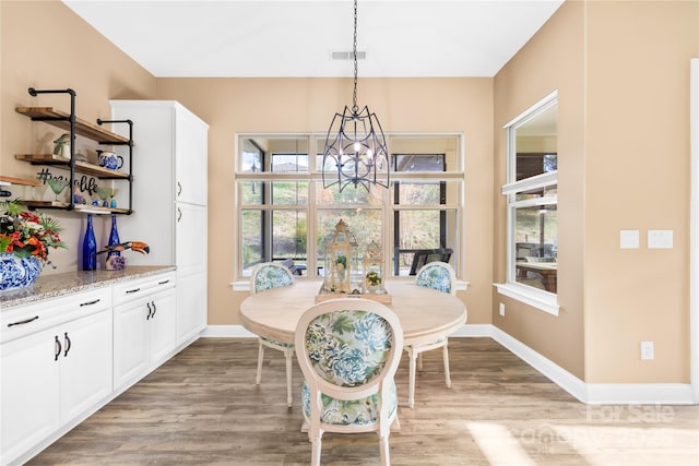 dining space with a chandelier and light hardwood / wood-style flooring