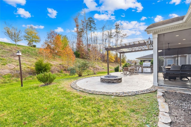 view of yard featuring exterior kitchen, an outdoor fire pit, and a patio