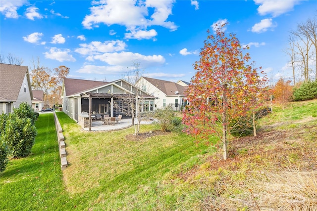 rear view of property featuring a lawn and a patio area