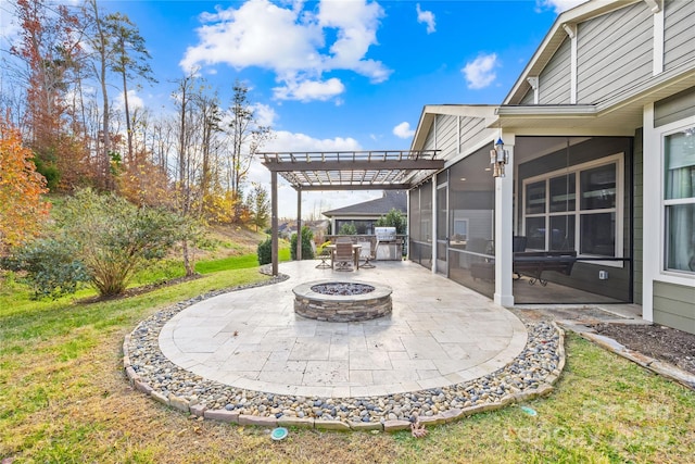 view of patio featuring an outdoor fire pit and a sunroom