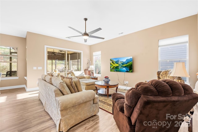 living room with ceiling fan and light hardwood / wood-style flooring