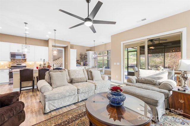 living room with light wood-type flooring and ceiling fan