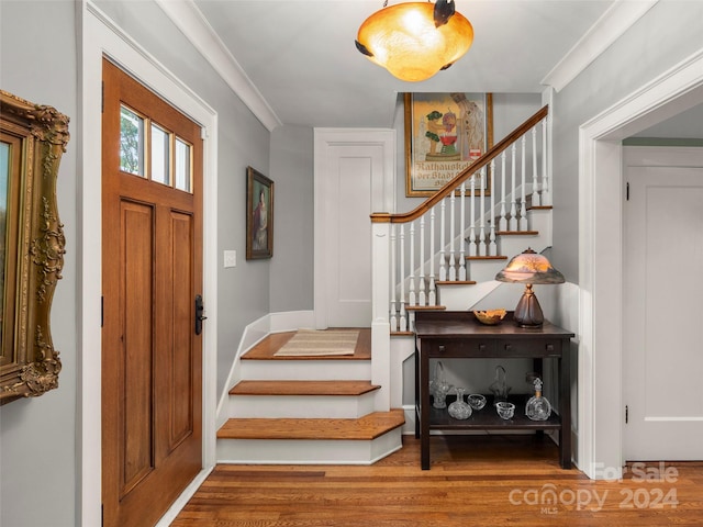 foyer entrance featuring ornamental molding and hardwood / wood-style floors