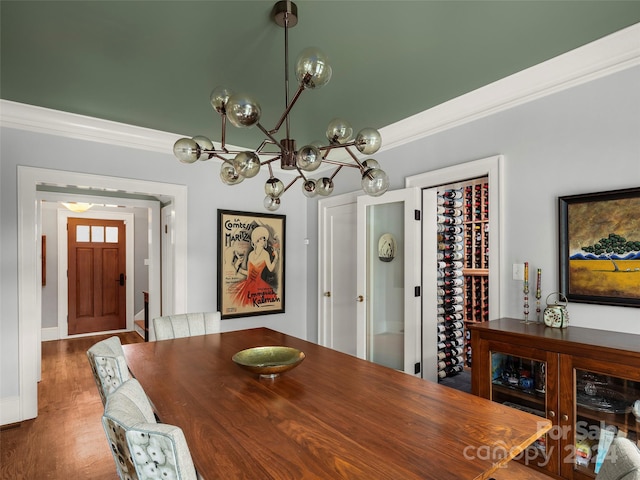 dining area featuring crown molding, a notable chandelier, and dark wood-type flooring