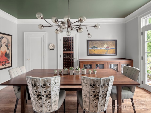 dining space with crown molding, hardwood / wood-style flooring, and a chandelier