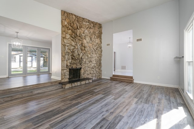 unfurnished living room featuring hardwood / wood-style floors, a fireplace, and french doors